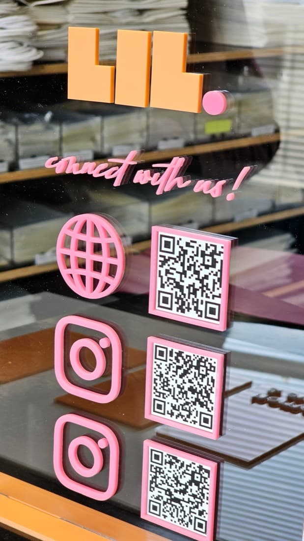Pink acrylic 'connect with us' social media and QR code window display