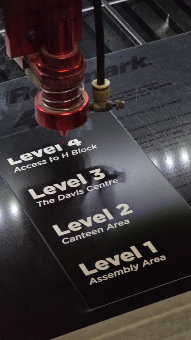Laser engraving a multi-level building directory sign in progress