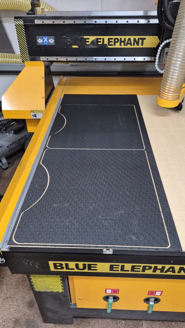 Blue Elephant CNC router with a custom cutting template machined into the bed mat