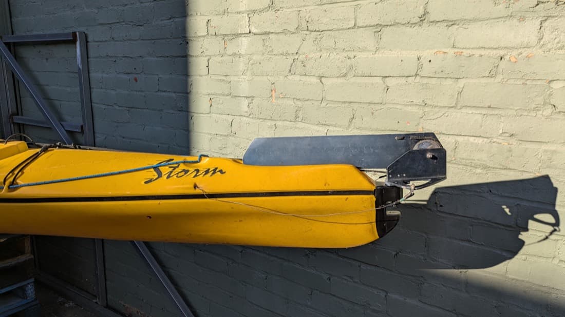 Yellow Storm kayak stored on a custom fabricated wall-mounted bracket