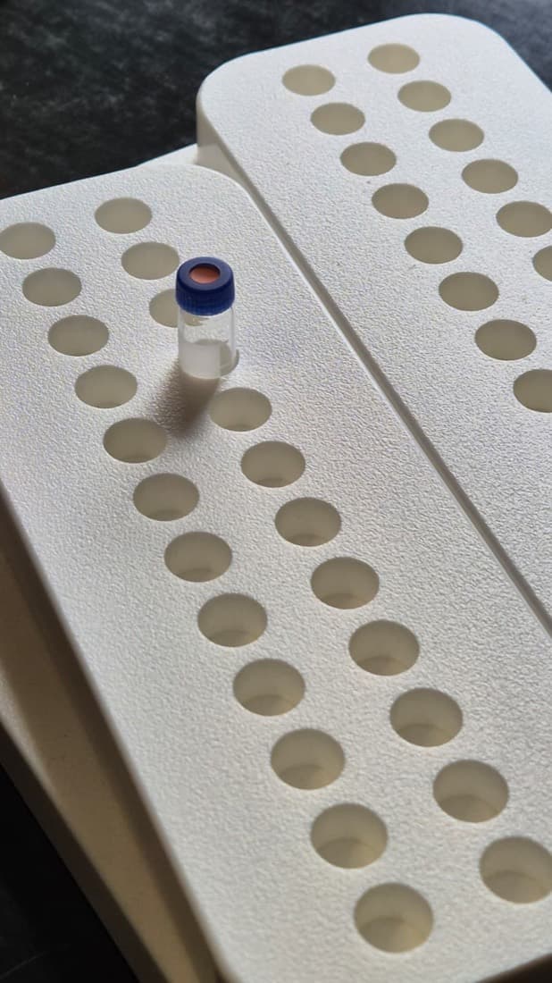 Custom-fabricated foam sample tray with rows of holes for storing laboratory test vials