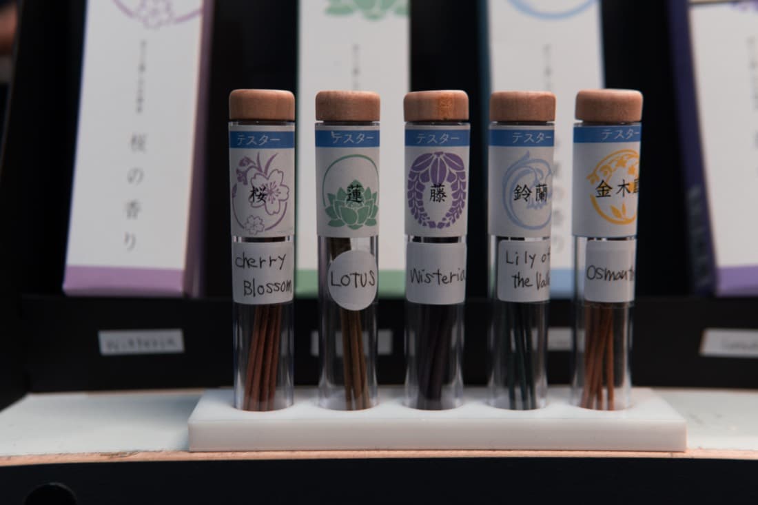 Retail incense tester display on a custom white acrylic stand with printed product cards