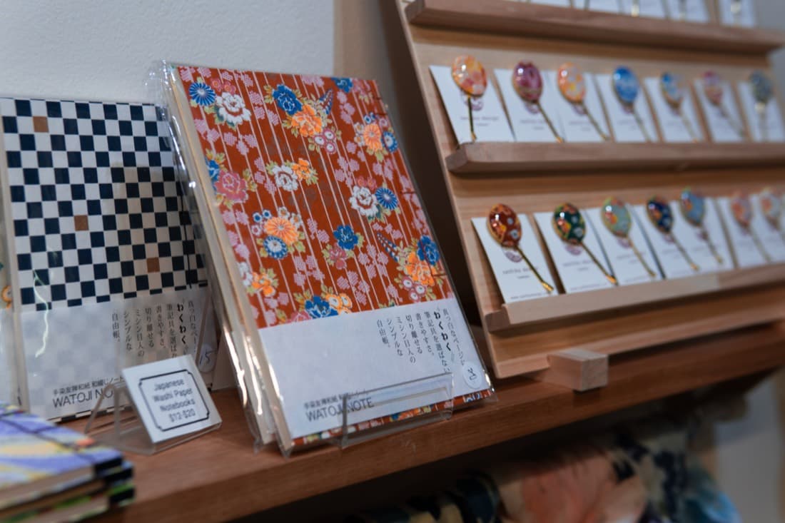 Shop shelf display of notebooks and decorative pins on timber retail risers