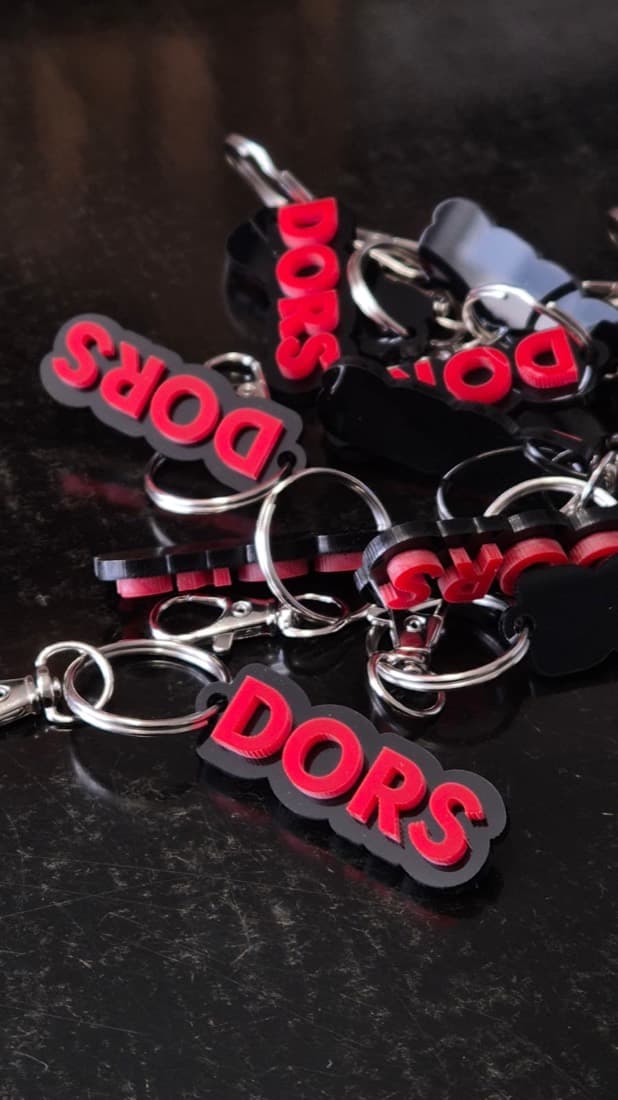 Custom red and black acrylic DORS branded keyring tags for point of sale