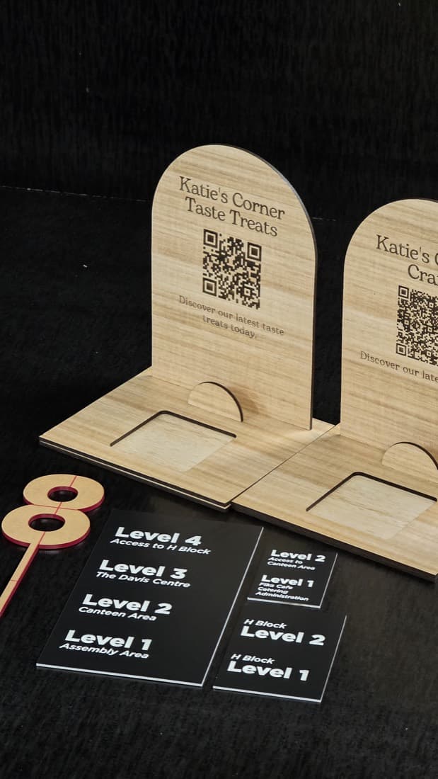 Laser-cut plywood QR-code display stands and acrylic wayfinding level signs for a tourism venue